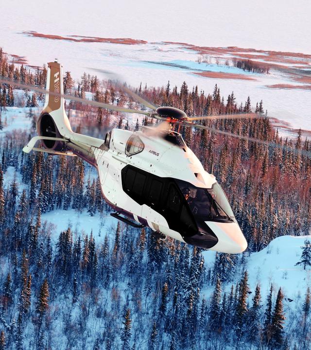 Helicopter flying above snow forest
